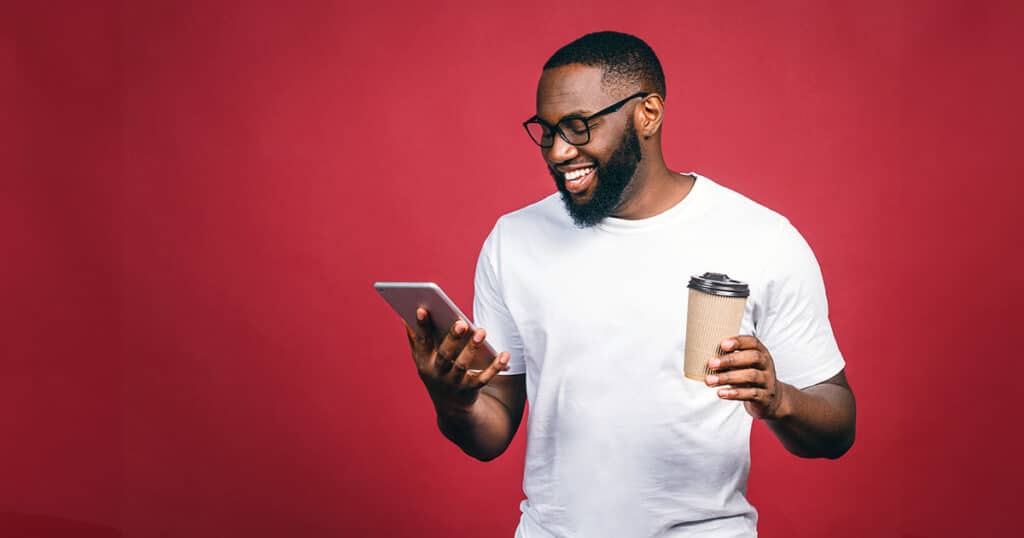 Smiling man holding digital device